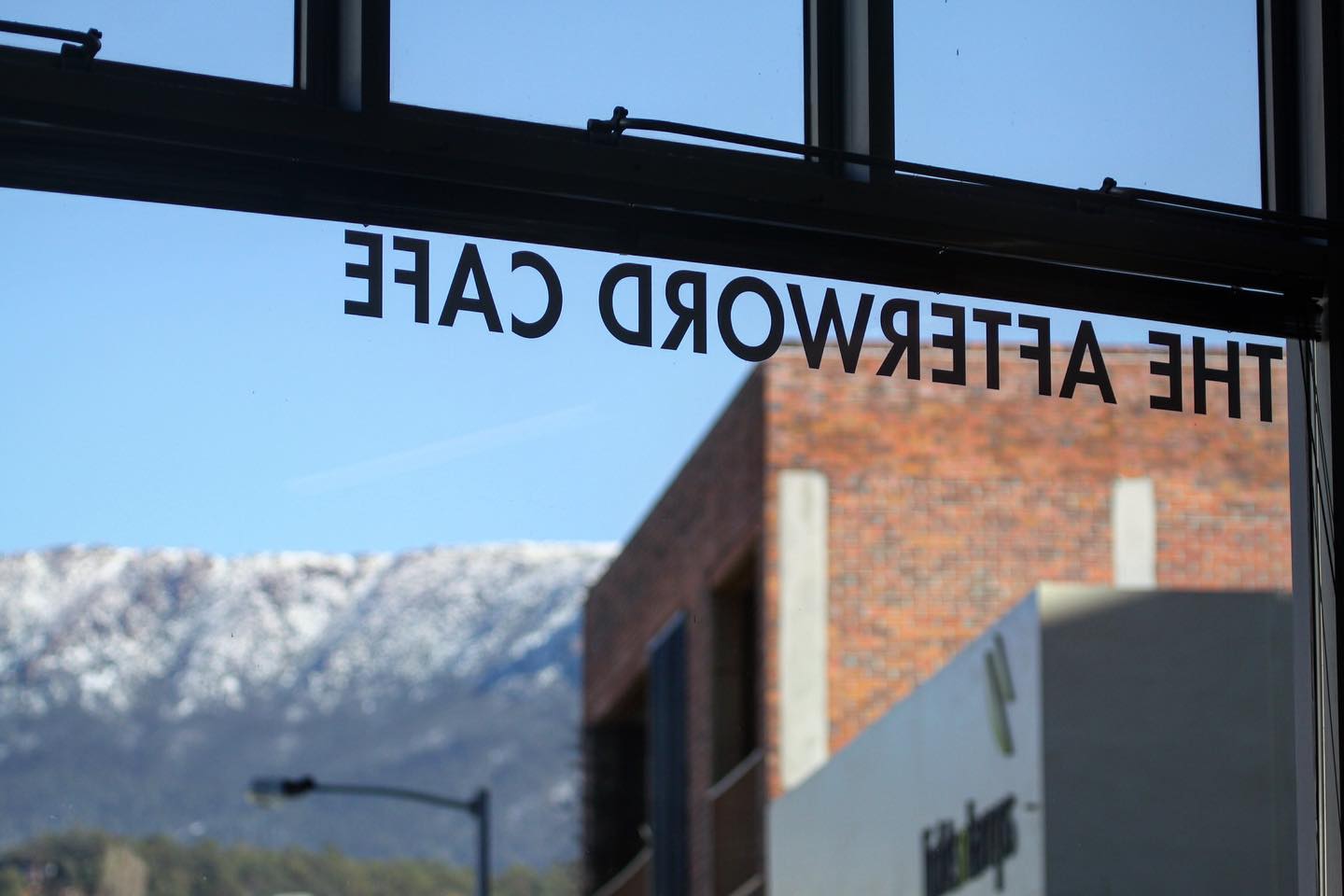 Photo of the inside of the Afterword Cafe, with a view of the mountain kunanyi through the window